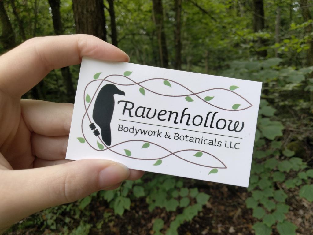 Photo of Ravenhollow business card with leafy background.
